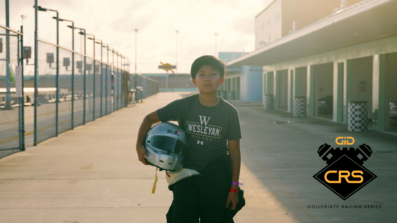 Joseph Saddington youngest pro driver holding racing helmet at Collegiate Racing Series event